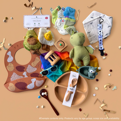 6-12 Month baby sensory gift box flat-lay of a 3-scoop order, including a food-themed avocado and fried egg pram toy from Living Textiles, 5 pairs of cotton knit socks from Spillykins, a dribble bib from Spillykins, a dummy clip from Zebra babies, a silicone food bib from Spillykins, a rainbow mini play silk from Play Silkies, a pincer puzzle from Totli, a rolling rattle from Totli, a bath toy from Toyslink, a silicone plate and fork set from My Little Giggles, and baby sunglasses from Ombra and Sole.