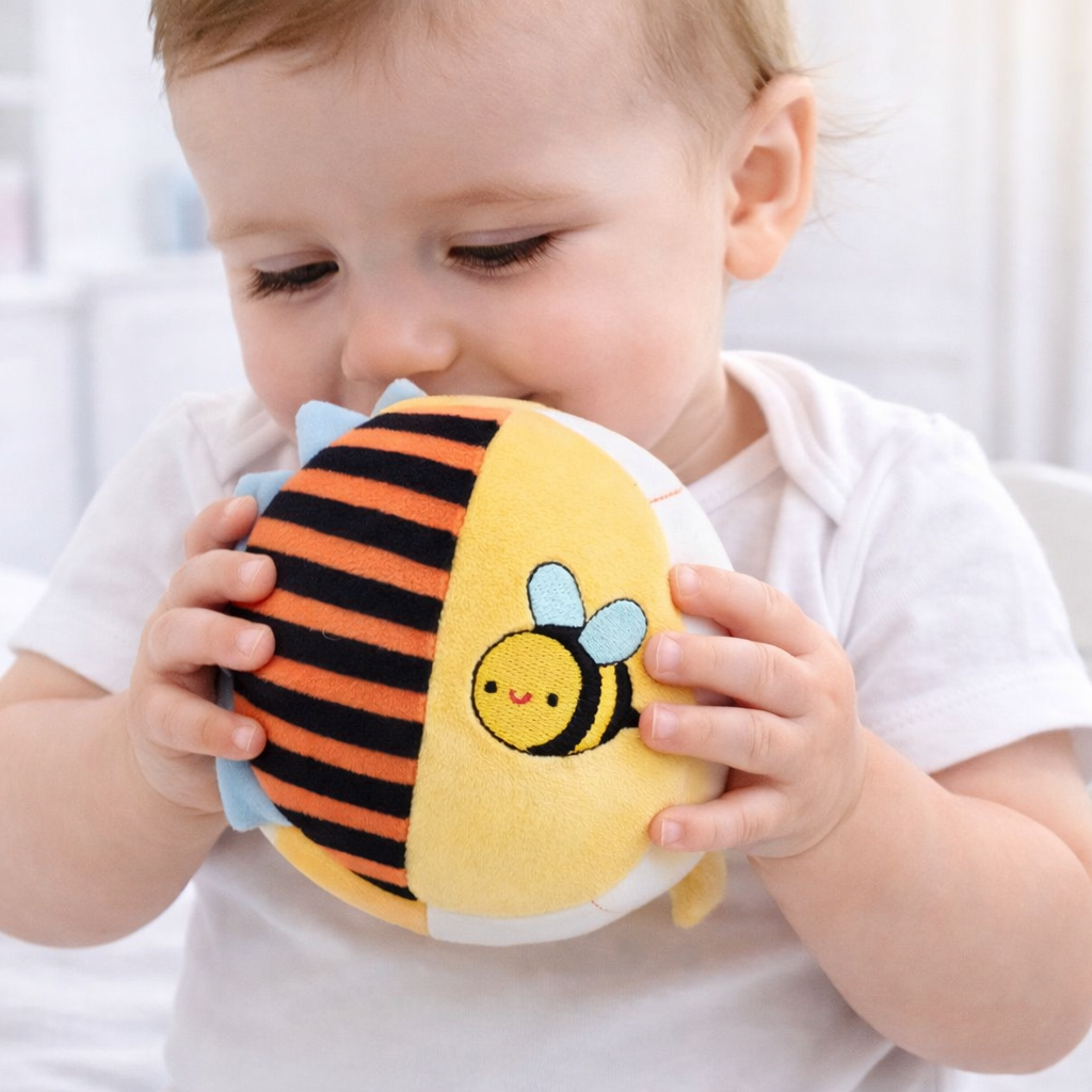 Child holding a plush toy with a bee design in a bright room.