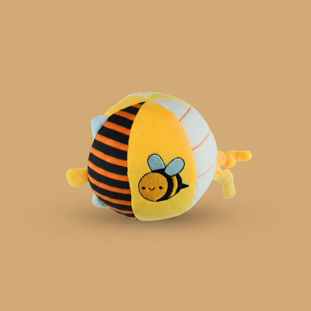 Plush toy shaped like a bee on a warm caramel background