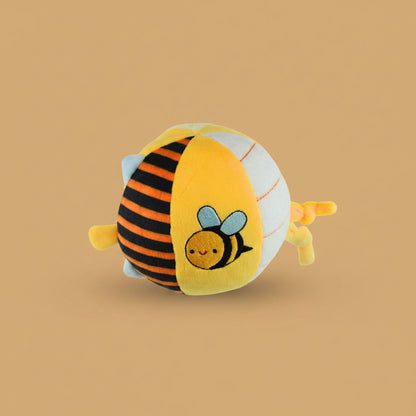 Plush toy shaped like a bee on a warm caramel background
