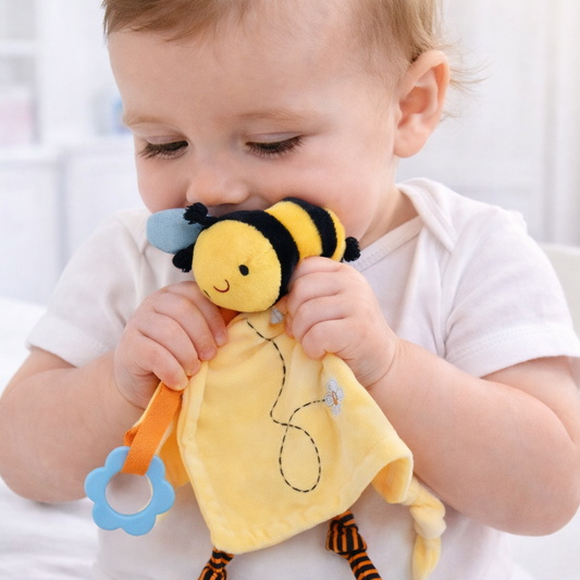 Baby holding a yellow bee-shaped toy with blue accents