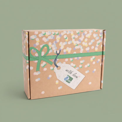 Gift box with confetti pattern, green ribbon, and 'with love' tag on a olive-green background